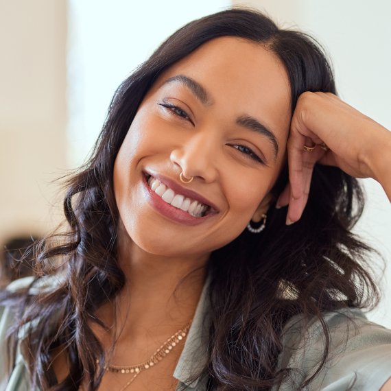 Patient holding up a dental shade guide guide to her teeth